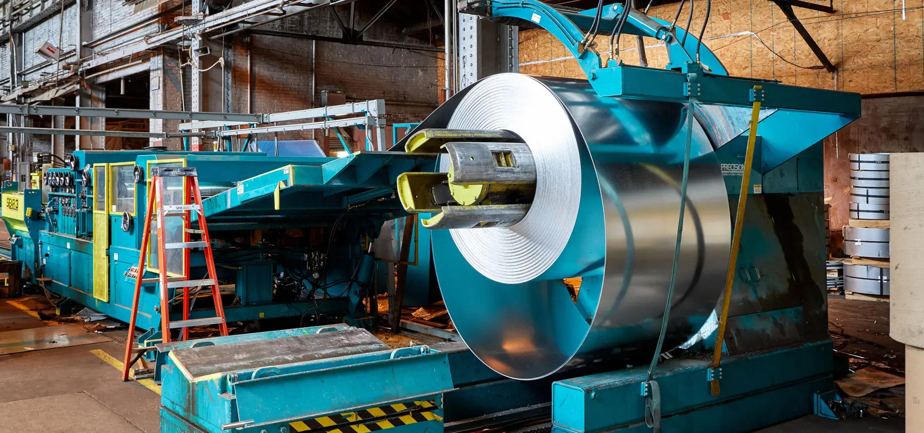 Steel coil loaded on the uncoiler of a processing line in Premium Steel Sales' Cleveland facility