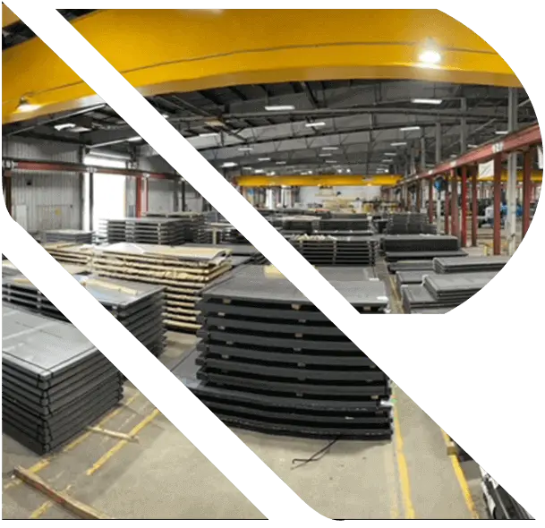 Stacks of stretcher-leveled steel sheet and plate under yellow overhead cranes in a Ratner Steel warehouse