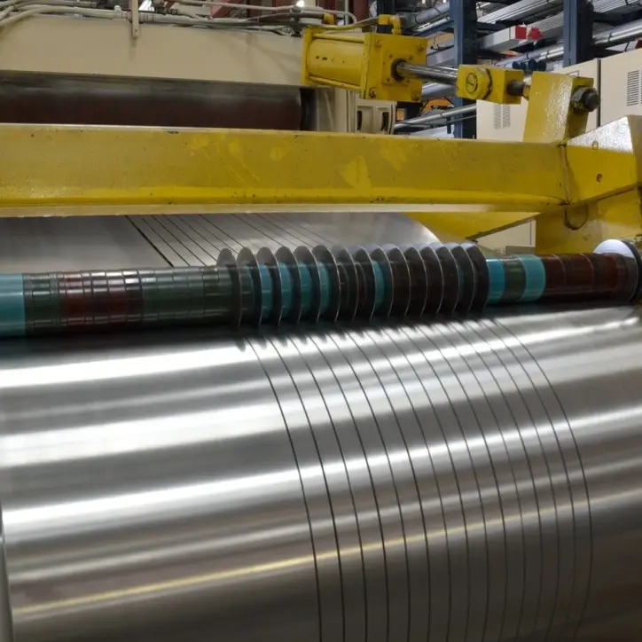 Slitting line knives cutting a bright stainless steel coil into narrow strands