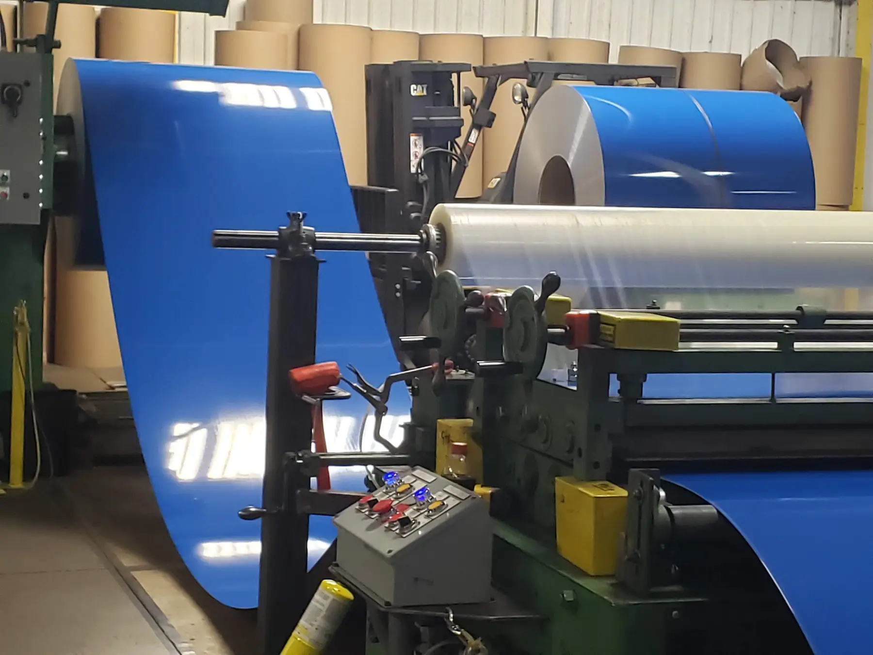 Blue pre-painted aluminum coil feeding into a processing line at Rockwell Metals in Lorain, Ohio