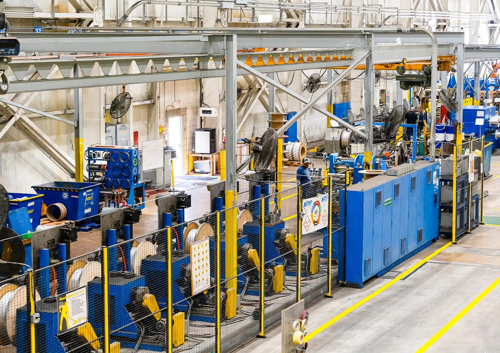 Rows of blue slitting and oscillate winding equipment inside Rolled Metal Products' Bensalem plant