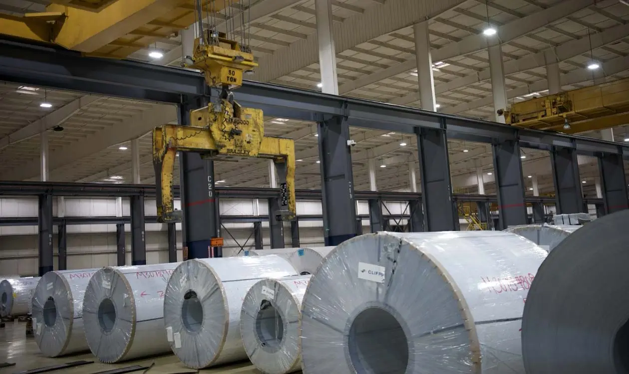Rows of steel coils beneath an overhead crane coil grab in RSDC's Holt, Michigan processing bay