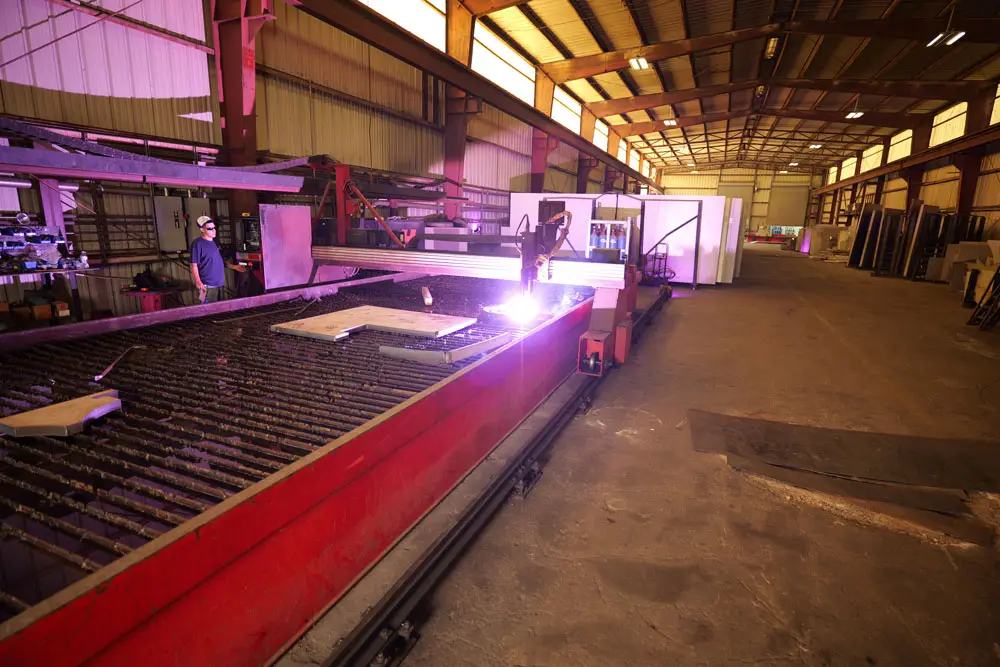 Plasma cutting tables cutting stainless plate inside the Sabre Alloys warehouse in Houston