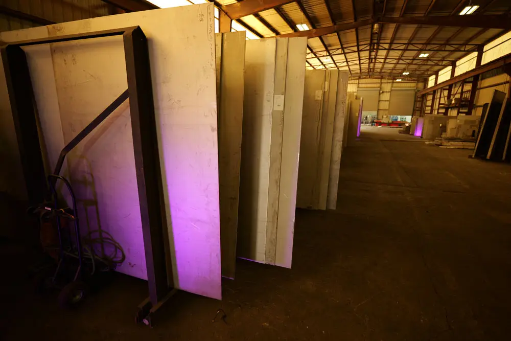 Stainless steel plates stored upright in racks at Sabre Alloys