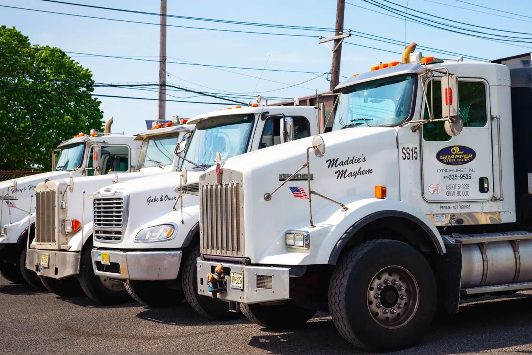 Row of white Shaffer Steel delivery trucks parked at the company yard