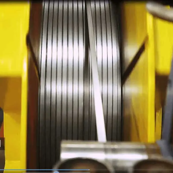 Narrow steel strip being traverse-wound into an oscillate coil at Siegal Steel