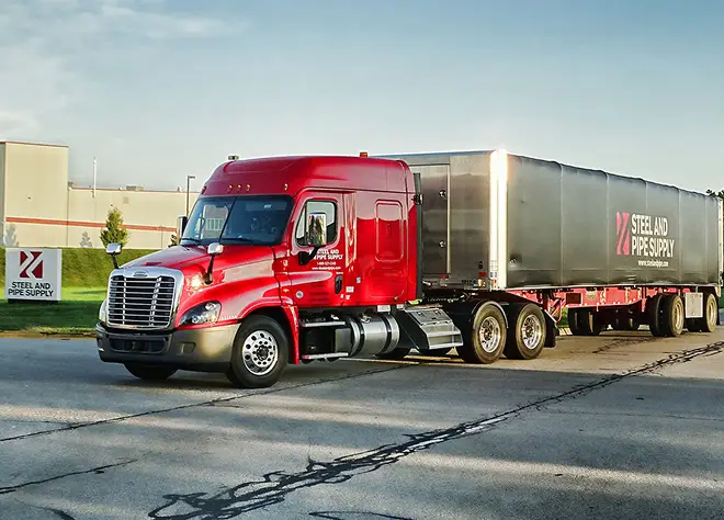Red Steel and Pipe Supply tractor-trailer parked outside a company facility