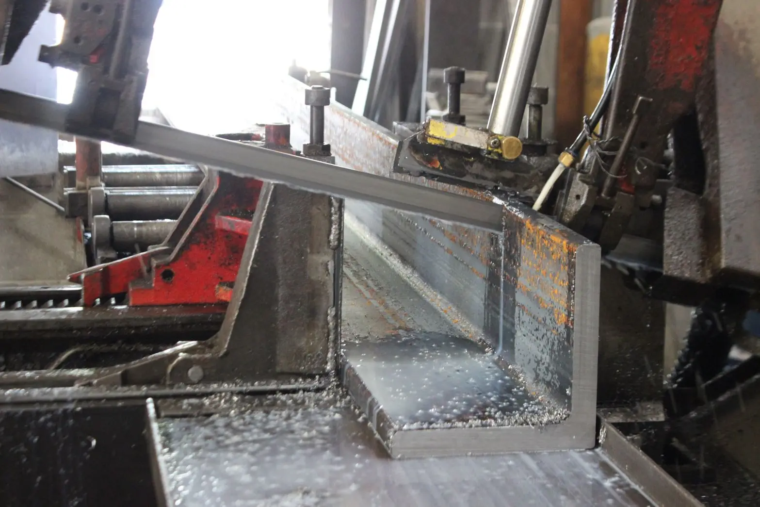 Band saw cutting a steel angle at Steel House in Indianapolis