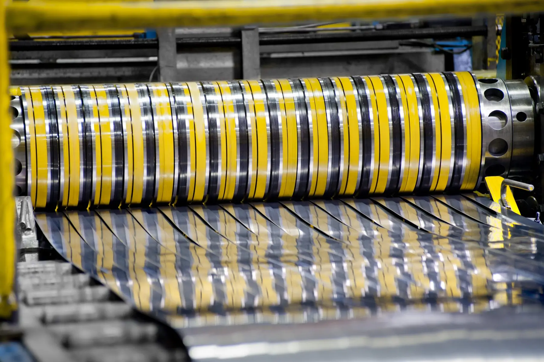 Close view of slitter knives cutting steel coil into narrow strands