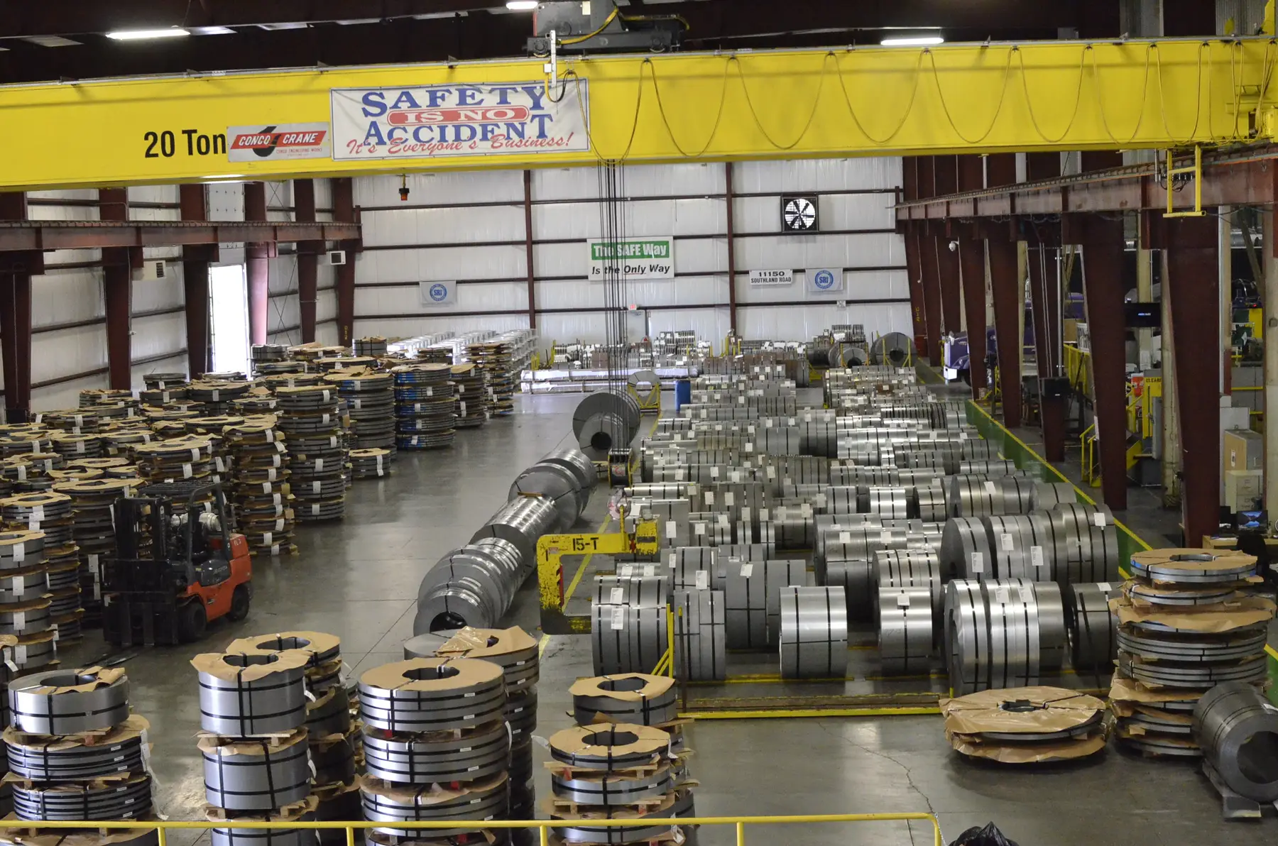 Slit steel coils staged on the warehouse floor under an overhead crane
