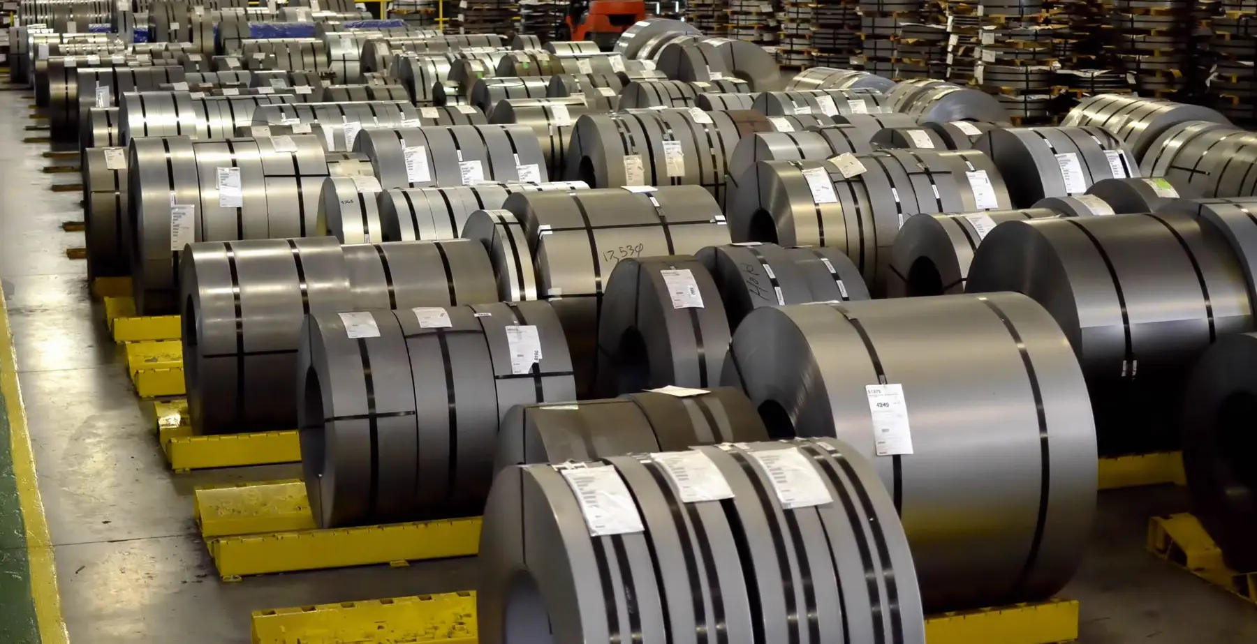 Rows of labeled slit steel coils ready for shipment in the warehouse