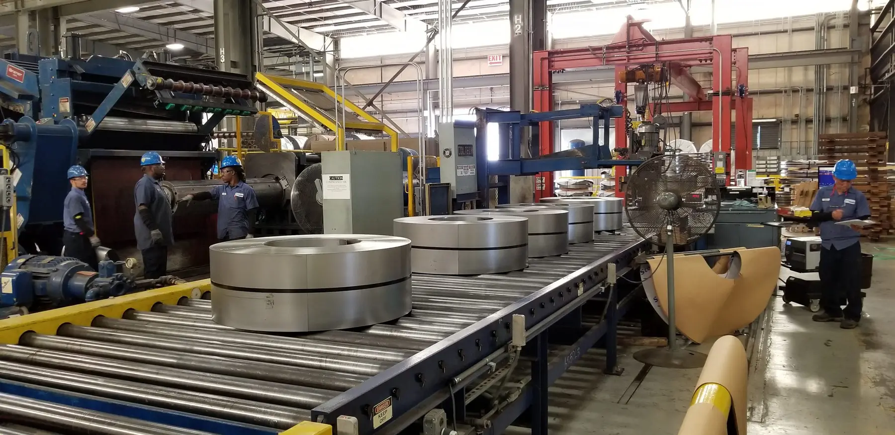 Coil processing line with banded slit coils on a roller conveyor