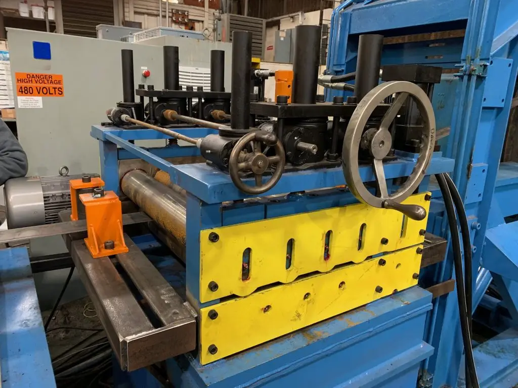 Blue and yellow edge conditioning machine with roller heads at Sunbelt Metal Processing