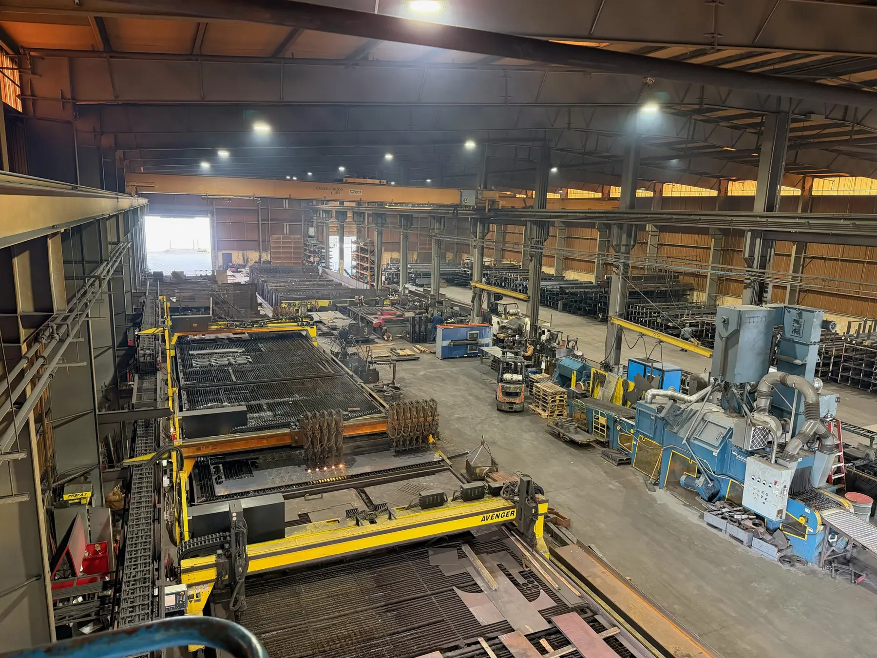 Overhead view of Tacoma Steel's long plate cutting tables and gantries in its crane-served bay