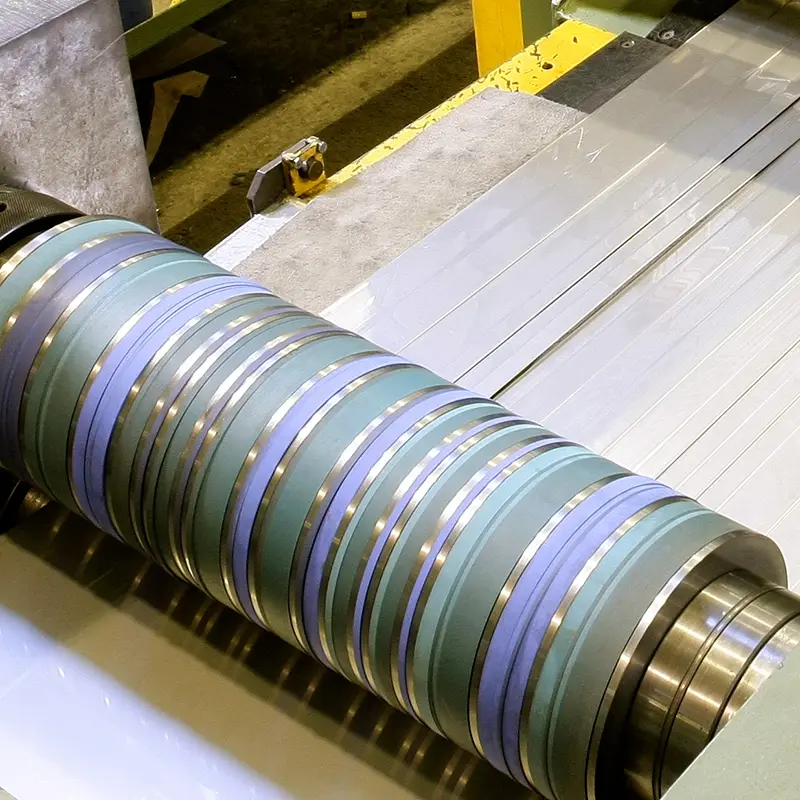 Slitter knives cutting bright stainless steel strip into narrow widths