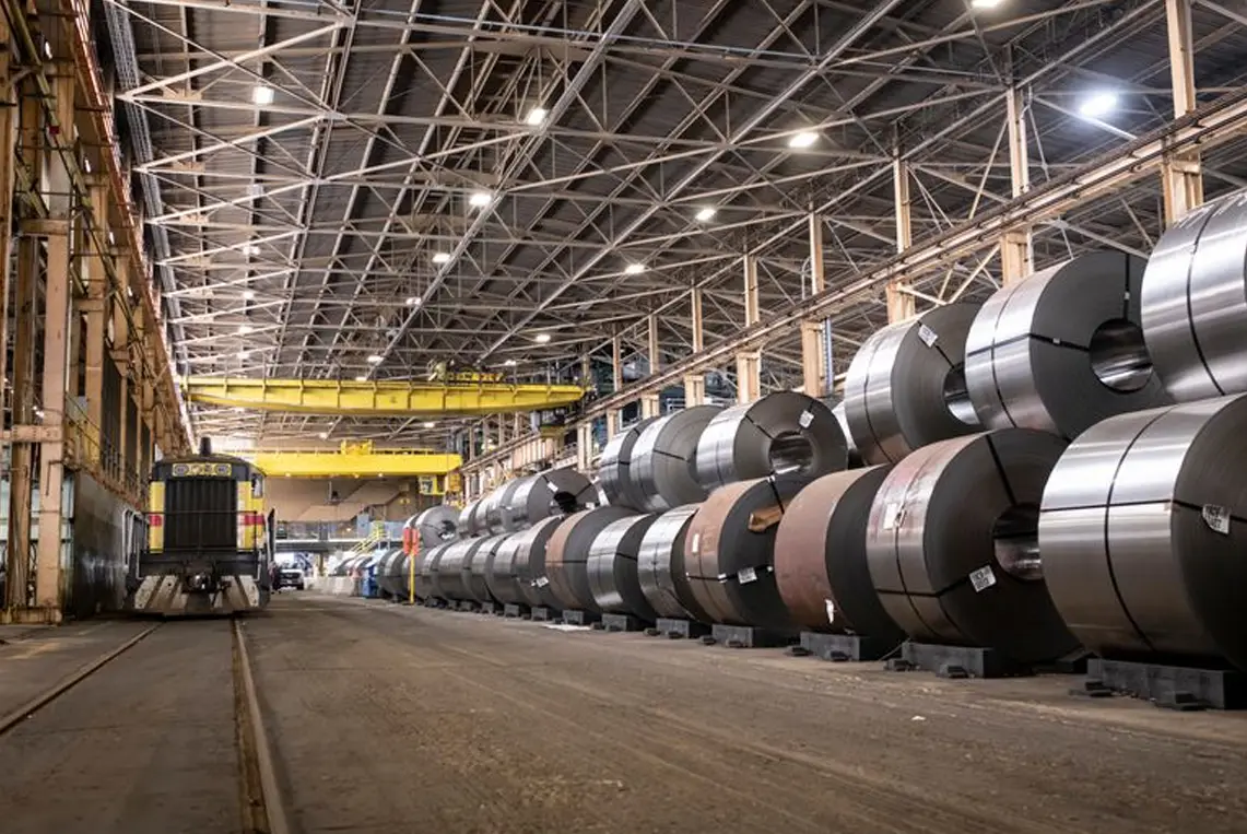 Long coil bay at The Techs with rows of galvanized steel coils under overhead cranes