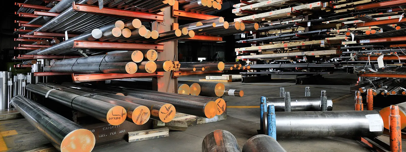 Racks of titanium and specialty metal round bar inventory in a Titanium Industries warehouse