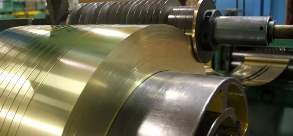 Brass strip being slit into narrow coils on a slitting line at United States Brass & Copper