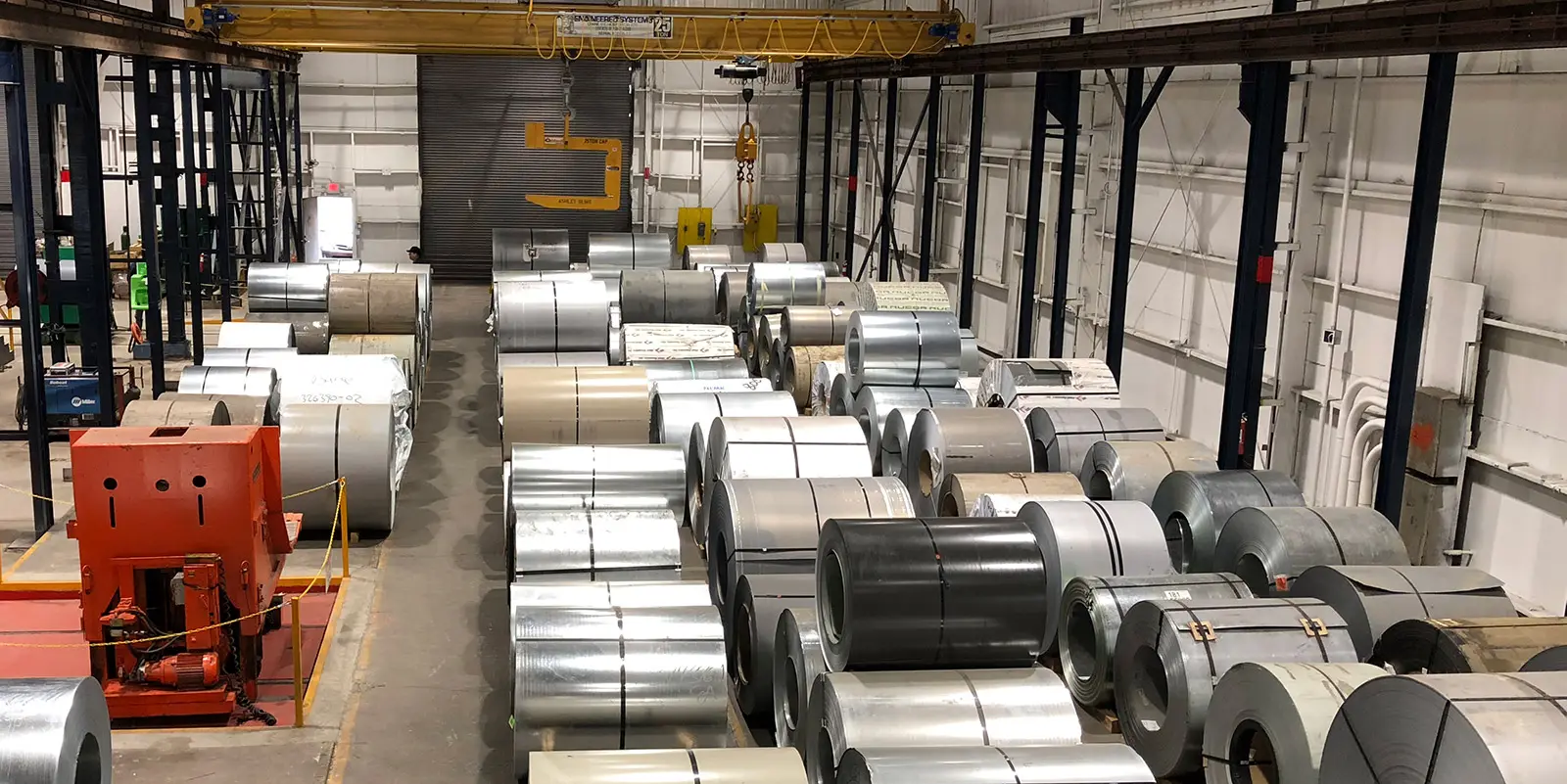 Rows of master steel coils under a 25-ton overhead crane in Vision Metals' coil storage bay