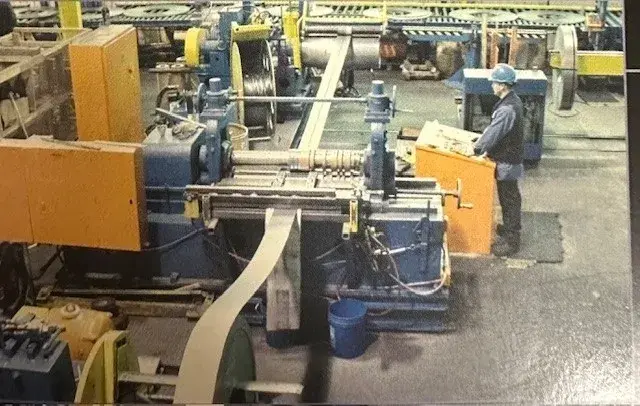 Operator at the control console of a slitting line as steel strip feeds through