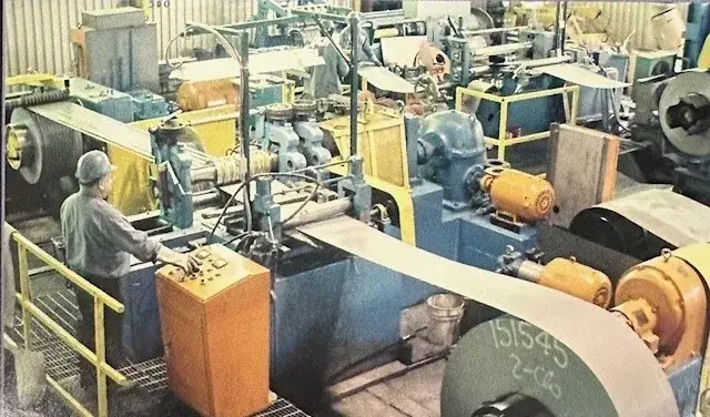 Operator running a narrow slitting line with a steel coil unwinding into it
