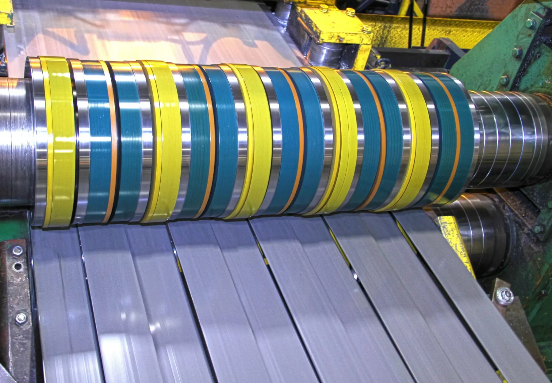 Steel strip passing through slitter knives and spacers on a Voss Industries slitting line
