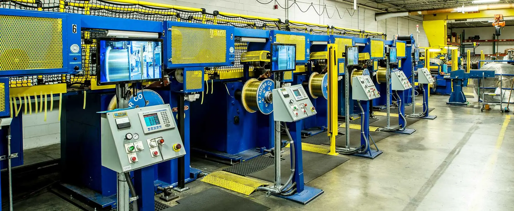 Row of traverse winding machines spooling metal strip at a Wieland Metal Services plant