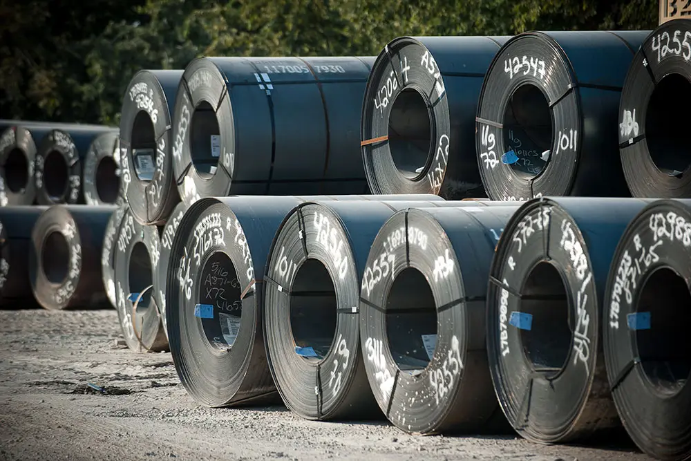Stacked hot-rolled steel coils in the Willbanks Metals yard in Fort Worth